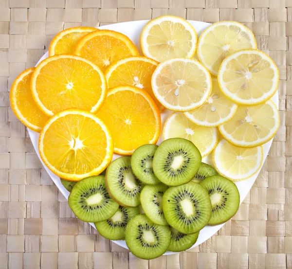 Färgglada tropiska frukter på tallrik — Stockfoto