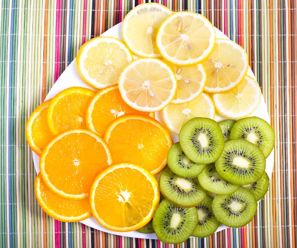 Owoce tropikalne na tabliczce na kolorowe tło — Zdjęcie stockowe