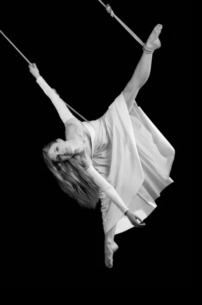Молода жінка гімнастка в білій сукні на мотузці — стокове фото