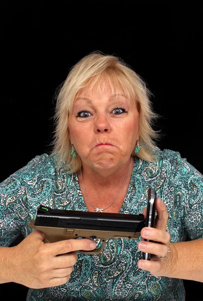 Oudere Blonde vrouw met mobiele telefoon en een pistool (4) — Stockfoto