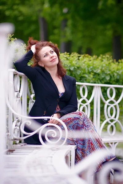 De mooie vrouw op een bankje — Stockfoto