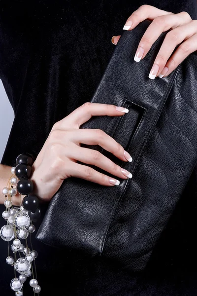 Schöne weibliche Hände mit Maniküre mit Handtasche — Stockfoto