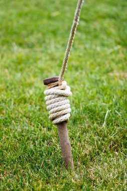 Close Up of Tent Stake Wrapped With Rope clipart