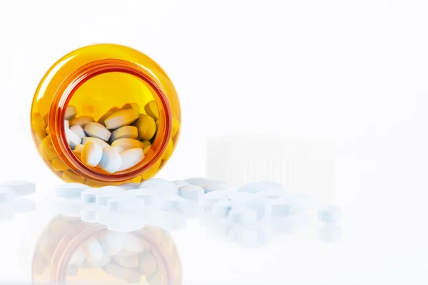 Tabletták ömlött a cumisüvegről a gondolatok a fehér háttér — Stock Fotó