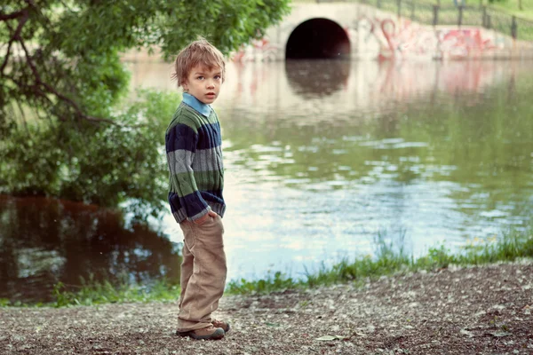 Zarif çocuk Nehri'nin kıyısında duruyor — Stok fotoğraf