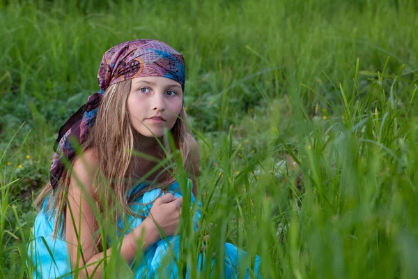 Schönes Mädchen sitzt auf grünem Gras, Sommer — Stockfoto