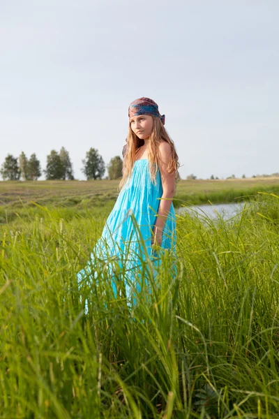 Beautiful girl stands on green field, summer, sunset — Stock Photo, Image