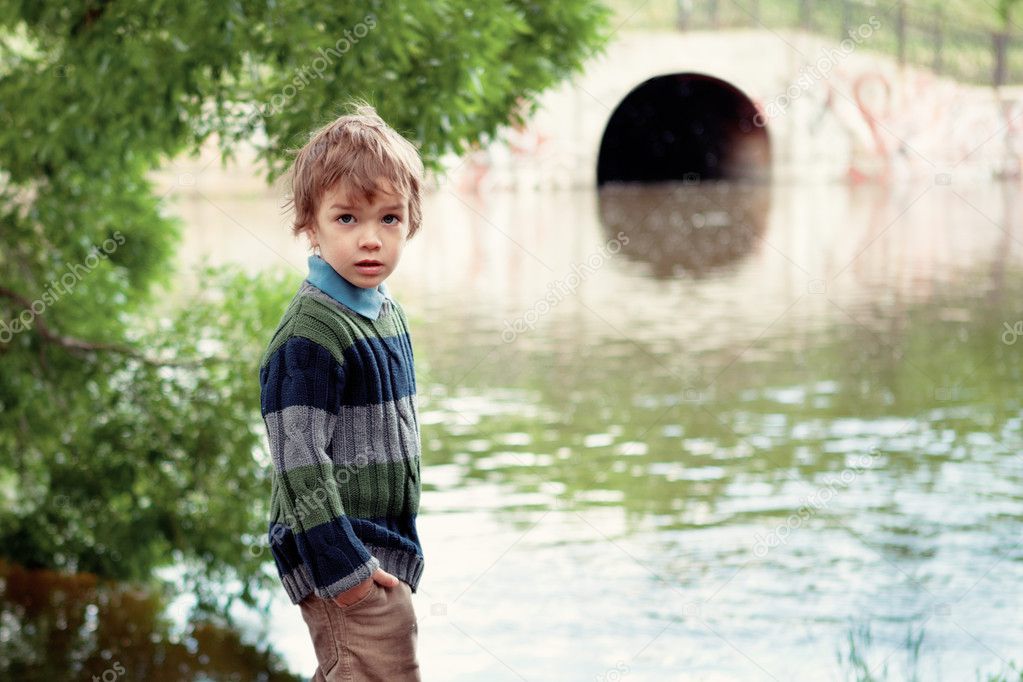 Elegant boy stands on banks of River