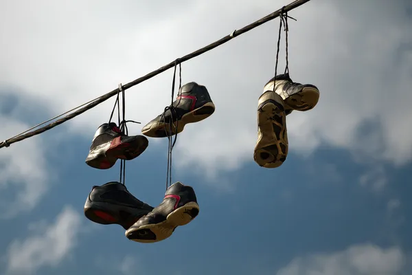 Πάνινα παπούτσια που κρέμονται σε μία τηλεφωνική γραμμή — Φωτογραφία Αρχείου