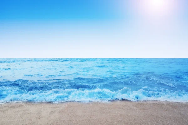Playa soleada con océano azul y cielo despejado —  Fotos de Stock