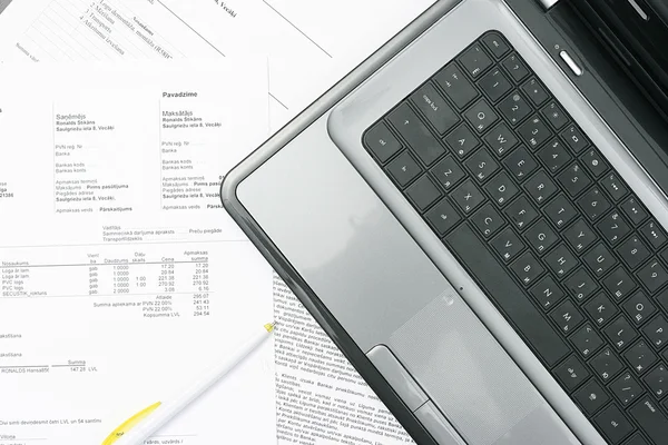 Masadaki laptop ve kağıt faturalar — Stok fotoğraf