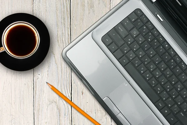 Laptop und Kaffeetasse auf Holztisch — Stockfoto