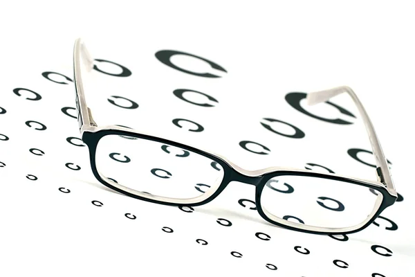 Black glasses on a eye sighttest chart — Stock Photo, Image