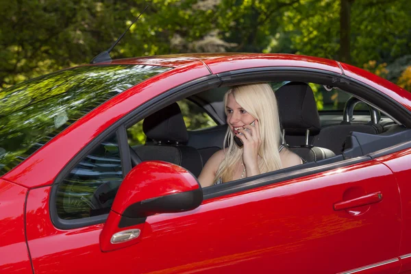 Uma jovem com um carro vermelho — Fotografia de Stock