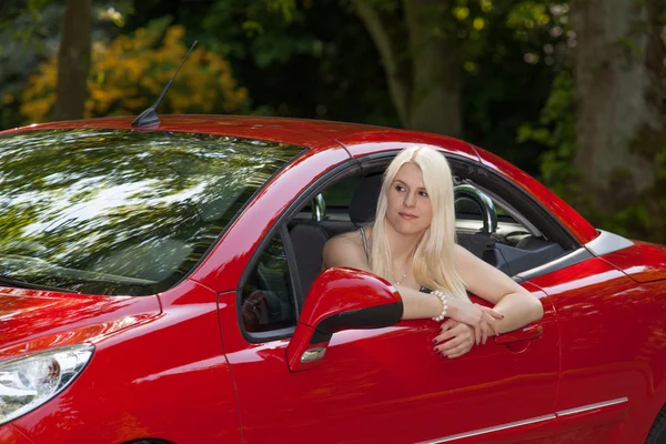 Молода дівчина з червоною машиною — стокове фото