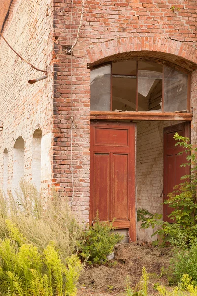 Een deur in een oude verwoeste muur — Stockfoto