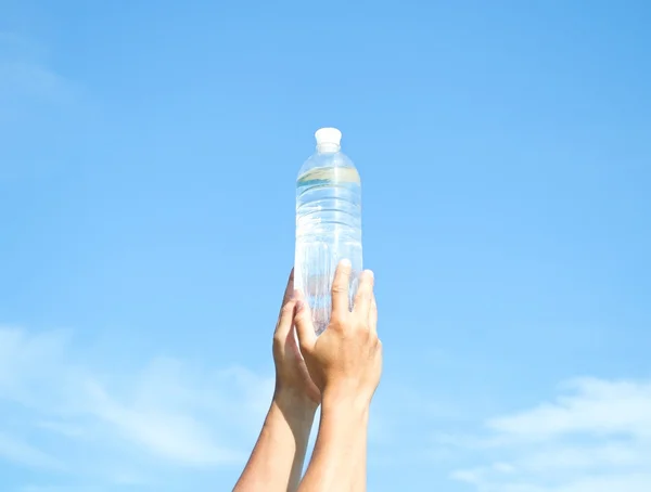 Руки з пластиковою пляшкою води — стокове фото