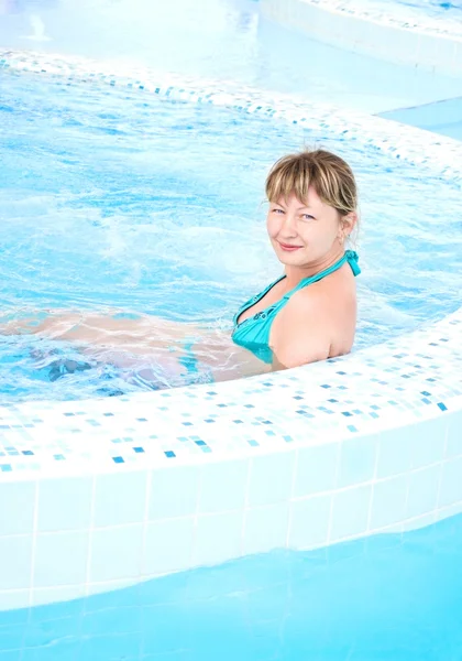 Mulher sentada numa piscina — Fotografia de Stock