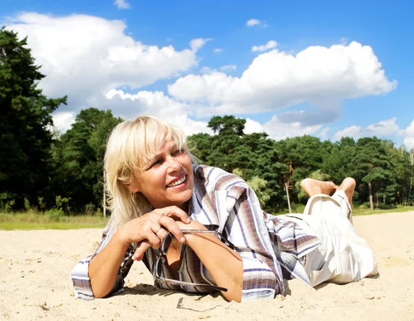 Žena ležící na písku — Stock fotografie