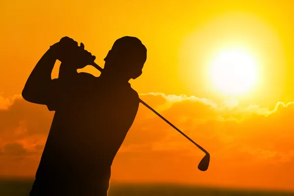 Foto van een golfer in zonsondergang — Stockfoto