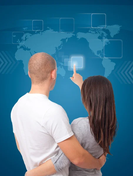 Couple browsing a touchscreen world map — Stock Photo, Image