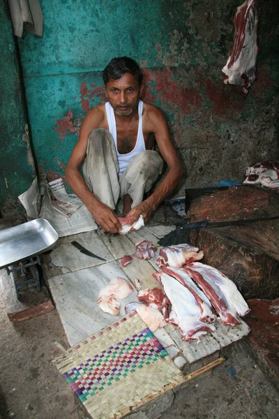 Uomo che taglia carne cruda, macellaio - Agra, India — Foto Stock