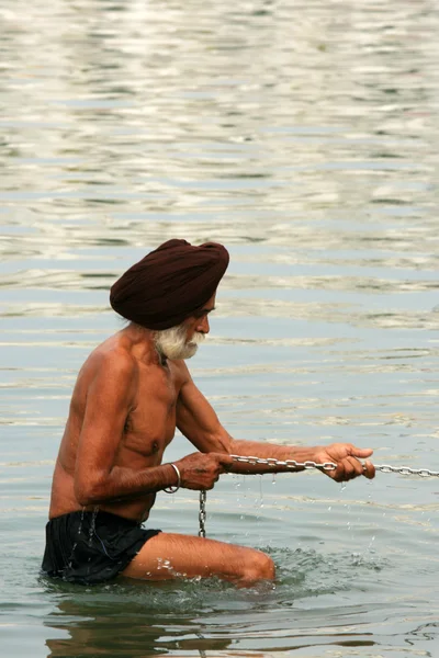 Sikh muž koupání v svěcenou vodou v golden temple — Stock fotografie