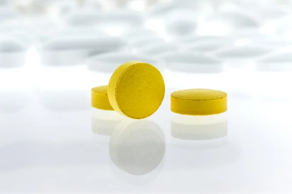 Yellow pills on white background — Stock Photo, Image