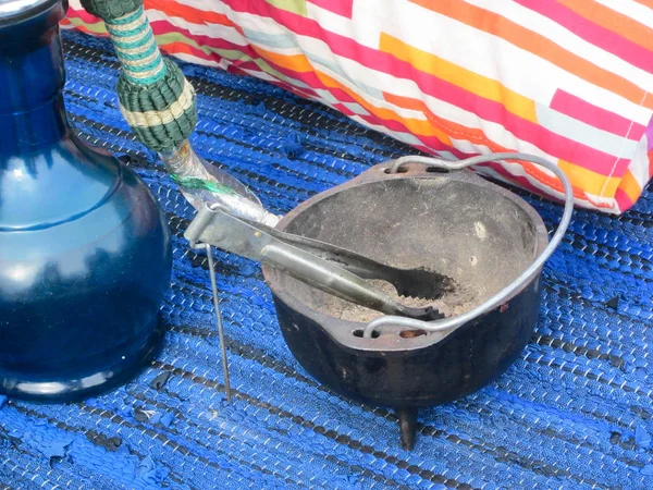 stock image Hookah with accessories and pillow on blue carpet, arabic tradition