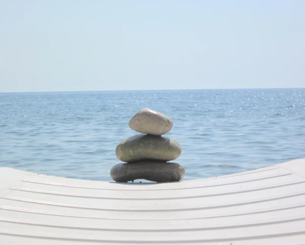 De stack van pebble stenen in zen concept op chaise longues — Stockfoto