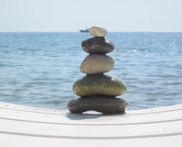 The stack of pebble stones in zen concept on chaise longues — Stock Photo, Image