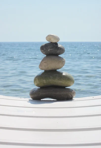 The stack of pebble stones in zen concept on chaise longues — Stock Photo, Image