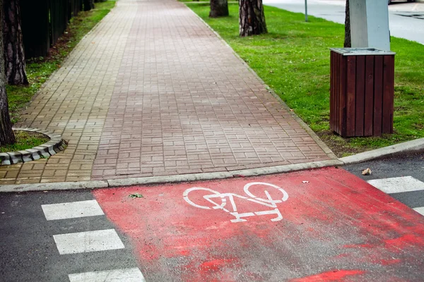 Red bicycle lane with white mark.
