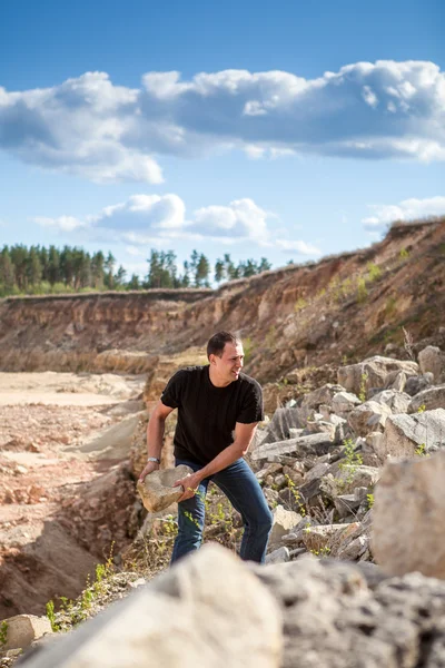 stock image The man picks up a stone on the career