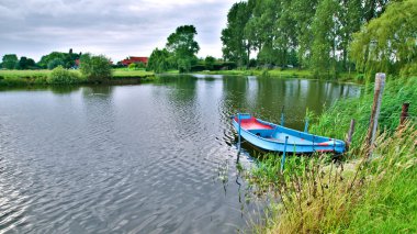 Slow River and a Blue Boat clipart