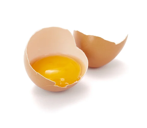 Закрыть половинкой разбитого яйца на белом фоне, с дорожкой вырезания — стоковое фото
