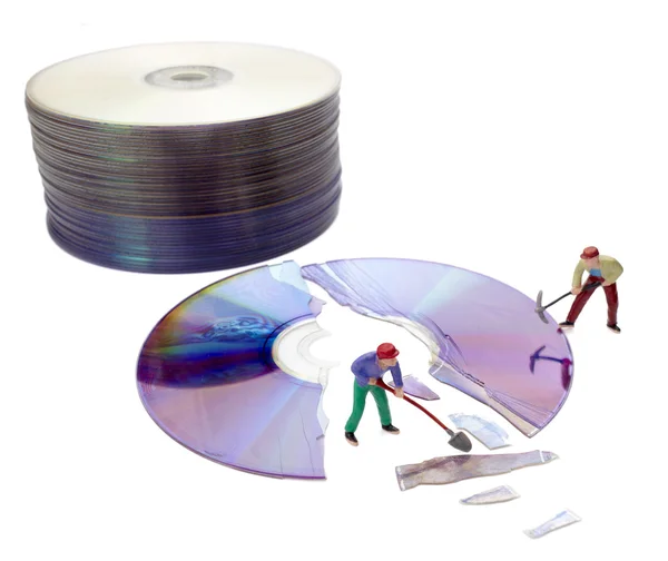Мініатюрні іграшкові працівники ремонтують комп'ютер зламаний компакт-диск — стокове фото