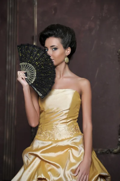 Красивая девушка в золотом платье — стоковое фото