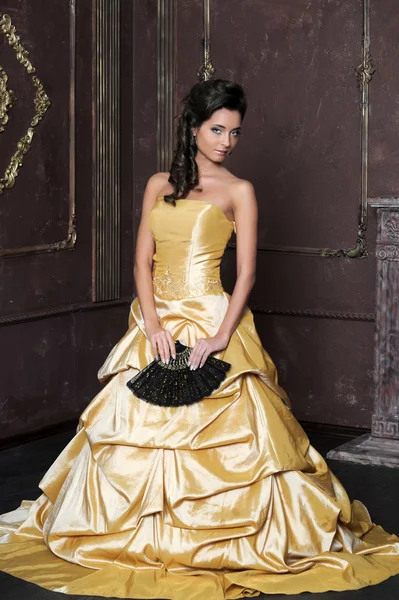 Vacker flicka i gyllene klänning — Stockfoto