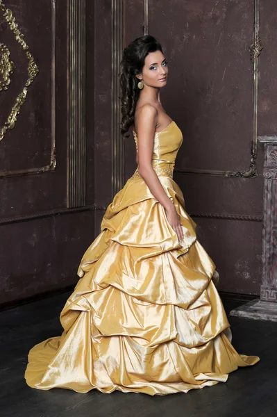 Schönes Mädchen im goldenen Kleid — Stockfoto