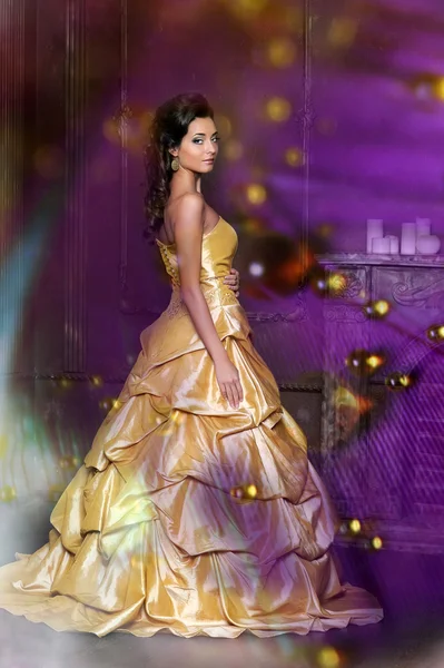 Красива дівчина в золотій сукні — стокове фото