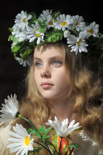Russisches Mädchen in einem Kleid und einem Kranz aus Gänseblümchen — Stockfoto