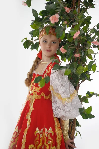 Chica rusa en vestido nacional junto a un árbol en flor — Foto de Stock