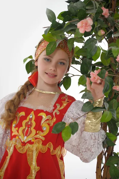 Russian girl in national dress next to a blossoming tree — Stock Photo, Image