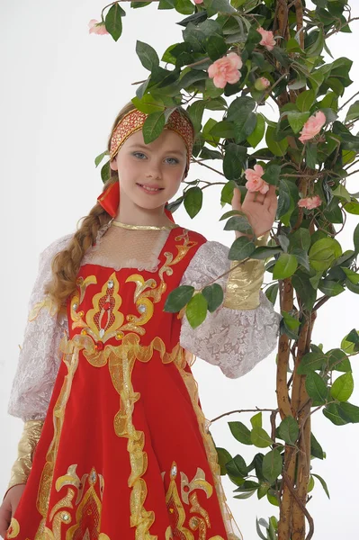 Chica rusa en vestido nacional junto a un árbol en flor — Foto de Stock