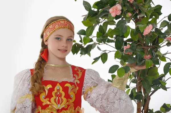 Russian girl in national dress next to a blossoming tree — Stock Photo, Image