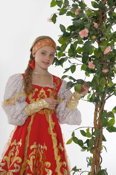 Rosjanka w strój obok kwitnących drzew — Zdjęcie stockowe
