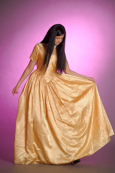 Model in een gouden jurk — Stockfoto