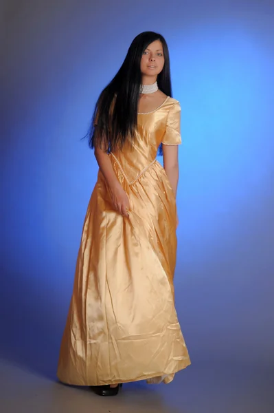 Модель в золотом платье — стоковое фото