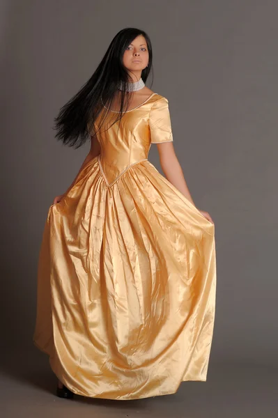 Model in een gouden jurk — Stockfoto